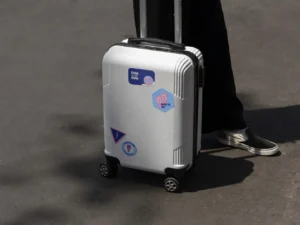 person carrying luggage with stickers